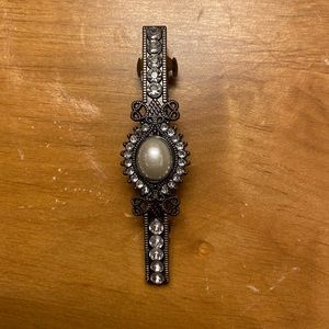 Silver vintage hair clip with shiny crystals and a big pearl in the middle.